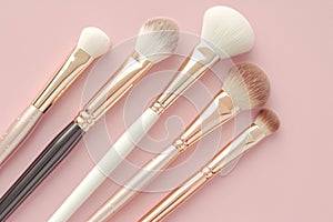 Elegant beauty brushes, white and gold, on gentle pink background