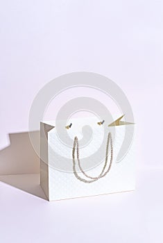 Elegant beige cardboard bag with a string on a purple background