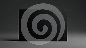 Elegant black card with subtle floral pattern on dark grey background with dramatic lighting