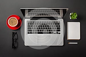 Elegant black office desktop with laptop and cup of coffee