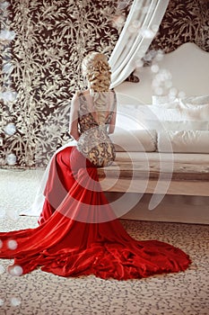 Elegant blond woman model wearing in luxurious red gown with lo