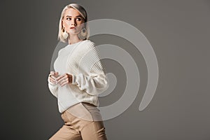 elegant blonde model posing in white knitted sweater