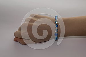 An elegant blue bracelet on the woman`s hand.