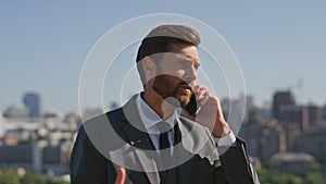 Elegant boss negotiating cellphone on sunny street closeup. Serious businessman