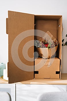 Elegant bouquet flower arrangement by florist in a box prepared for transport on a wooden table