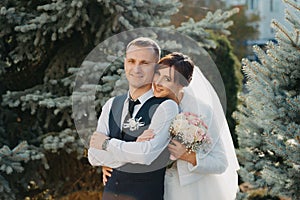 Elegant bride and groom posing together outdoors on a wedding day. Groom and Bride in a park. wedding dress. Bridal