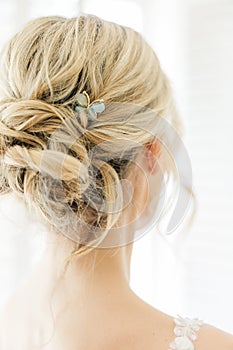 Elegant bride with hair styled in a sophisticated bun with a butterfly pin