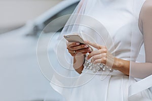 Elegant bride with phone in hands