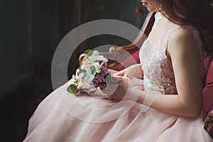 Elegant bride in a pink ress with a wedding bouquet