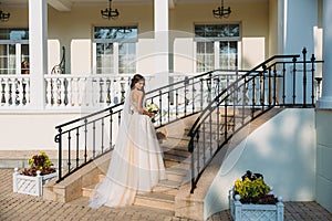 Elegant bride with wedding flowers bouquet, attractive woman in wedding dress. Young girl in a white dress goes the