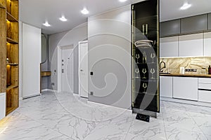 Elegant bright entrance hall with a pedestal, wardrobe and mirror with gray granite floor tiles.