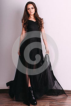 Elegant brunette lady posing in black evening dress. Studio shot