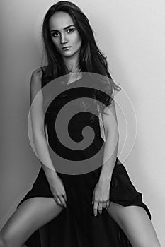 Elegant brunette lady posing in black evening dress. Studio shot