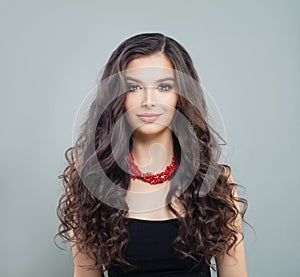 Elegant brunette woman model with makeup, curly long hair and red coral necklace