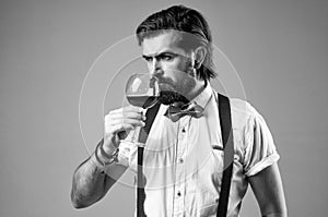 elegant brutal man in formal wear has groomed hair drinking wine, sommellier