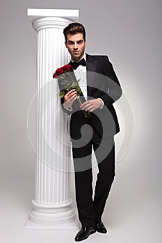 Elegant business man holding a bouquet of red roses