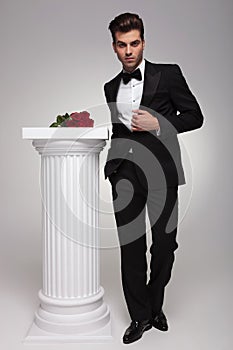 Elegant business man posing near a white column photo
