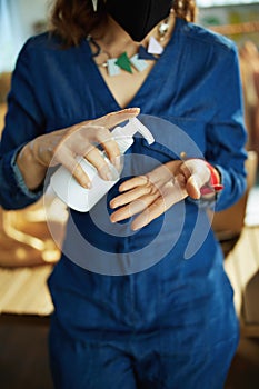 Elegant business owner woman disinfecting hands in office