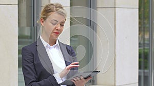 Elegant business woman with tablet computer near office building. close up