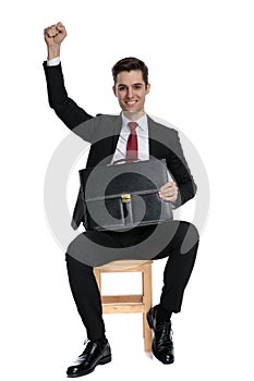 Elegant businessman celebrating and holding his briefcase