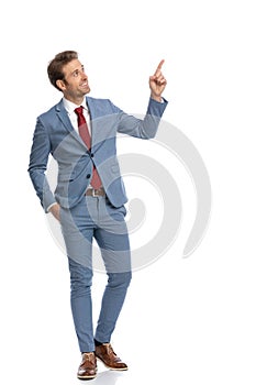 Elegant businessman looking to side and pointing finger up and side