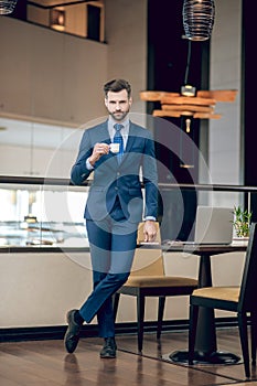 Elegant businessman in a nice suit having coffee