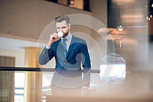 Elegant businessman in a nice suit having coffee