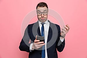 Elegant businessman reading texts and making funny faces