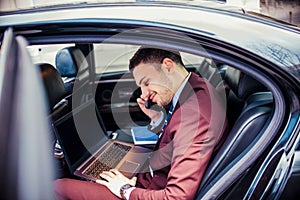 Elegant businessman sitting in stretch limo