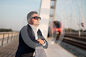 Elegant businessman standing on the bridge