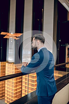 Elegant businessman standing and looking concentrated