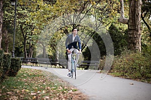 Elegant businessman traveling to work by bike