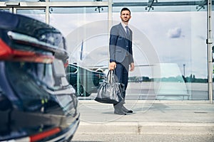 Elegant businessman waiting for a shuttle bus near the airport