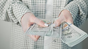 Elegant Businesswoman Displaying Multiple U.S. Dollar Bills, Conceptualizing Financial Success and Economic Prosperity