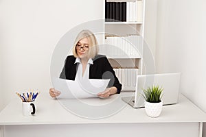 Elegant businesswoman in glassess working in the white office with paper.