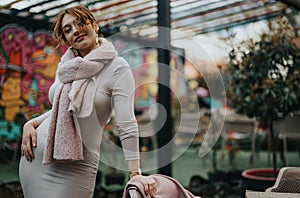 Elegant businesswoman with a stylish pink scarf and coat at a cafe photo