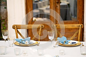 Elegant and chic wedding table setting in gold and blue colors and fresh flowers. Soft selective focus