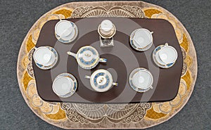 Elegant Chinese tea set on a black table. Top view of empty cups and teapot. Porcelain products. Dishes for tea and coffee. The