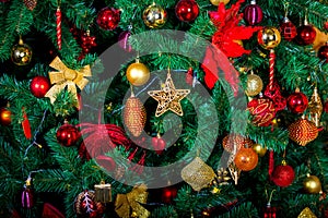 Elegant Christmas background, green eco tree from plastic decorated with many colorful gold and red toys