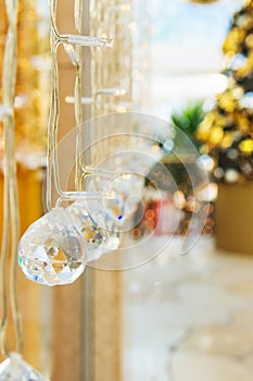 Elegant Christmas New Year decorations crystal balls sparkling in bokeh lights. Festive fir tree in the background