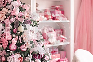 Elegant Christmas tree decorated with toys balls and ribbons in a bright interior. Soft focus.