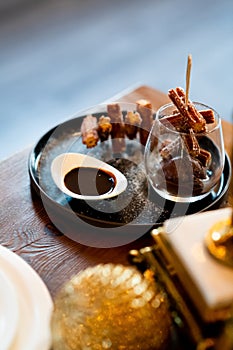 Elegant Churros with Sugar and Chocolate Sauce on Fancy Display in Glass and Plate Gastronomy Close Up