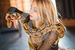 Elegant circus actress posing with a python