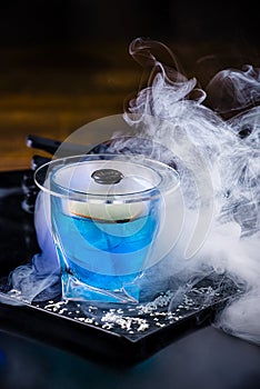 An elegant, classy shot of a dark blue blueberry cocktail in a crystal glass