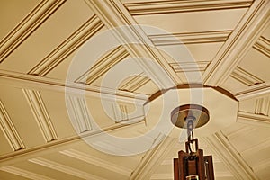 Elegant Coffered Ceiling with Classic Light Fixture, Warm Indoor Ambiance photo