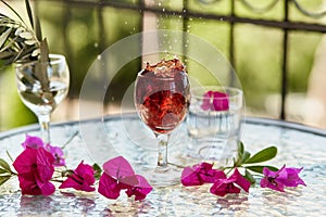 Elegant and colorful explosion of red wine in the glass. Summer bright cocktails on the background. Decorative pink