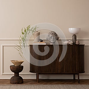 Elegant composition of living room interior with copy space, wooden sideboard, gray sculpture, vase with green leaves, wooden