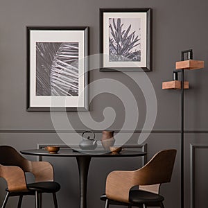Elegant composition of living room interior with mock up poster frame, black round table, stylish chair, wooden floor, lamp, wall