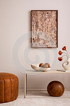 Elegant composition of living room interior with mock up poster frame, broen pouf, stylish bowl with coconut, vase with dried