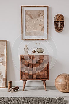 Elegant composition of masculine room decor with small wooden cupboard, two mockup paintings and vintage accessories.